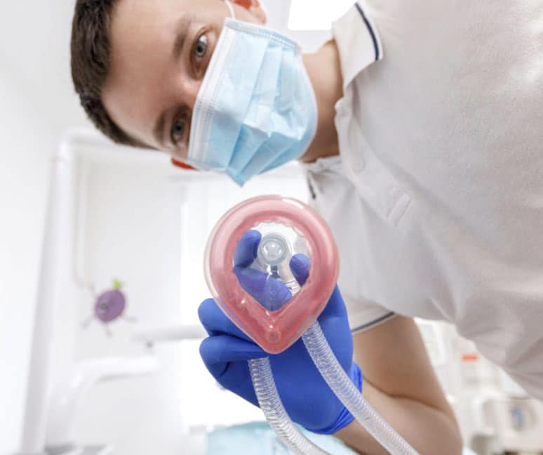 Dentist holding a nitrous oxide mask before sedation